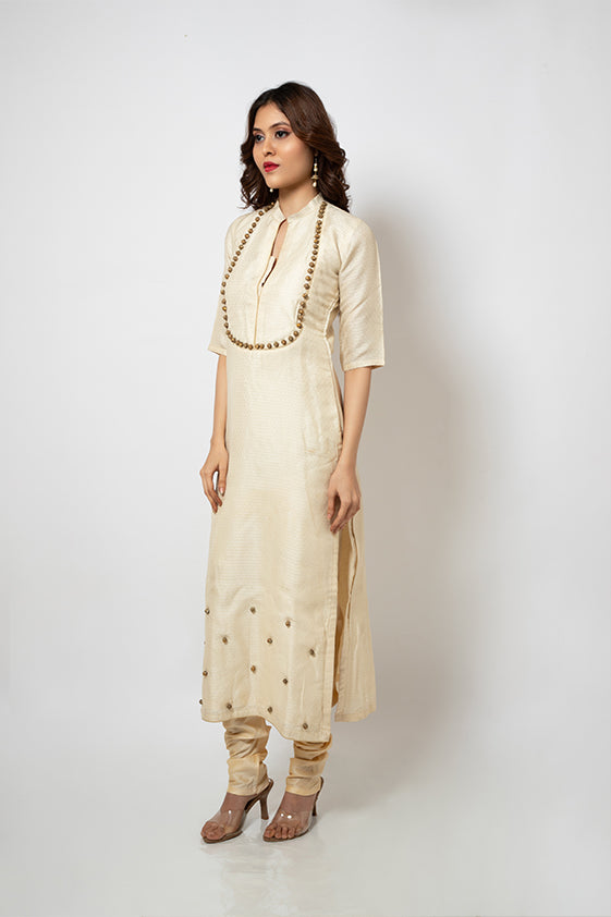 Off white brocade suit with golden beads hand embroidered around neckline