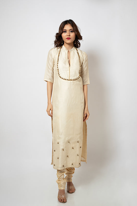 Off white brocade suit with golden beads hand embroidered around neckline